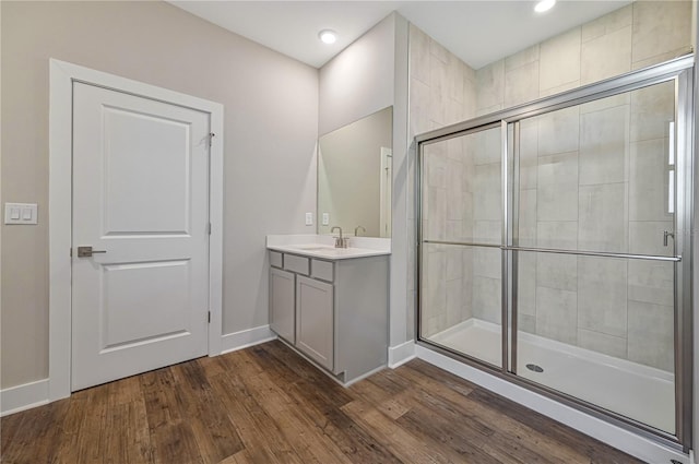 bathroom with wood-type flooring, vanity, and walk in shower