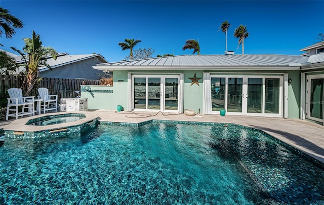 back of property featuring a pool with hot tub, a patio, and french doors