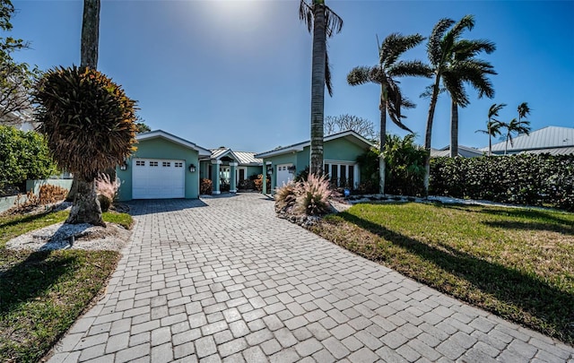 single story home with a garage and a front lawn