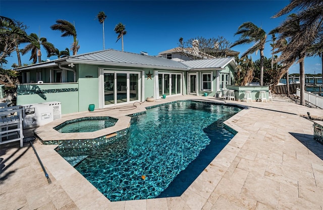 view of pool with an in ground hot tub and a patio