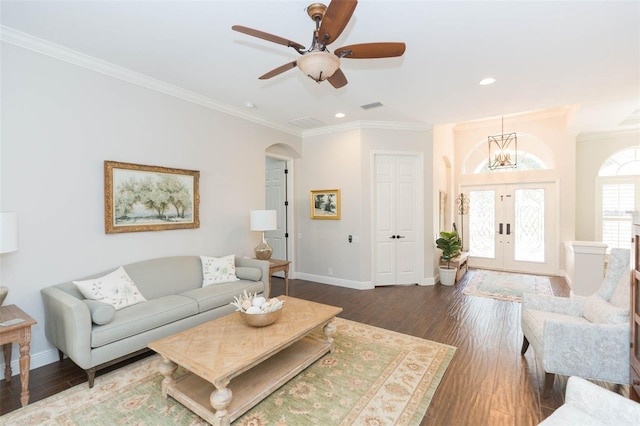 living room with ceiling fan with notable chandelier, french doors, crown molding, and dark hardwood / wood-style flooring