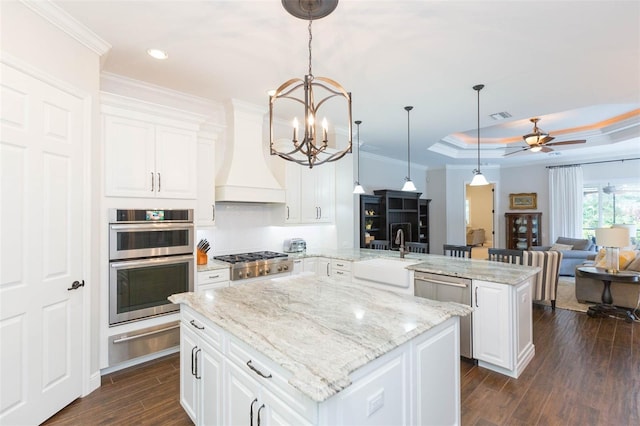 kitchen featuring white cabinetry, sink, kitchen peninsula, a center island, and dark wood-type flooring