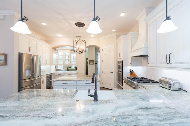 kitchen featuring white cabinetry, premium range hood, decorative light fixtures, and appliances with stainless steel finishes