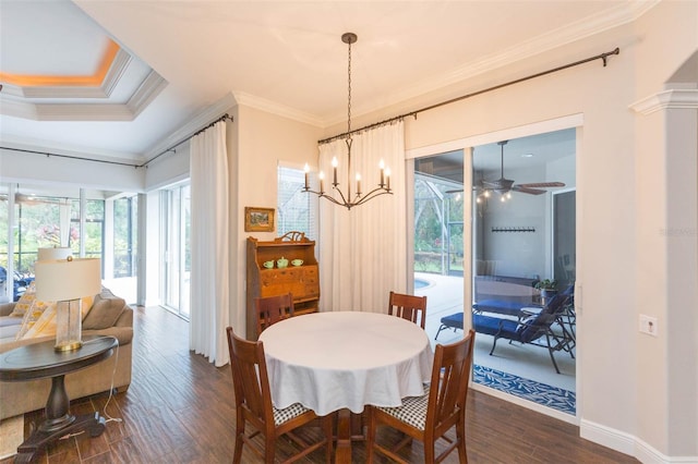 dining room featuring dark hardwood / wood-style flooring, ornate columns, crown molding, and ceiling fan with notable chandelier