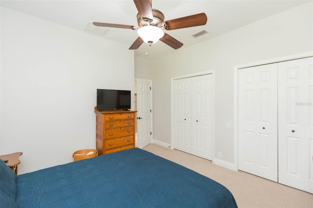 carpeted bedroom with multiple closets and ceiling fan