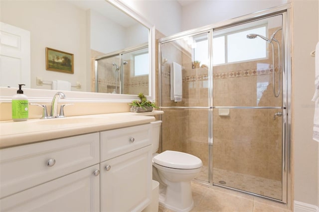 bathroom featuring toilet, vanity, tile patterned flooring, and a shower with shower door