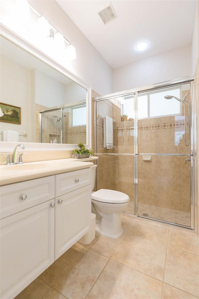 bathroom featuring an enclosed shower, vanity, tile patterned floors, and toilet