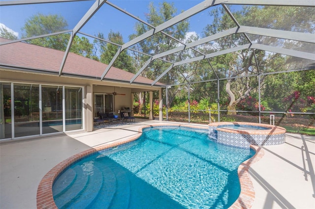 view of pool featuring glass enclosure, ceiling fan, an in ground hot tub, and a patio area