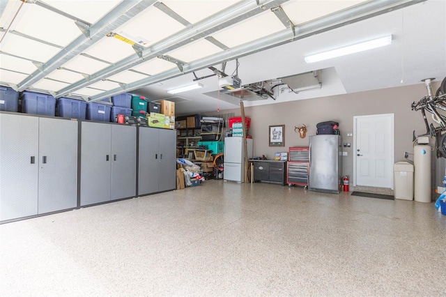 garage featuring a garage door opener, refrigerator, and white refrigerator