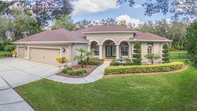 mediterranean / spanish-style house featuring a garage and a front yard