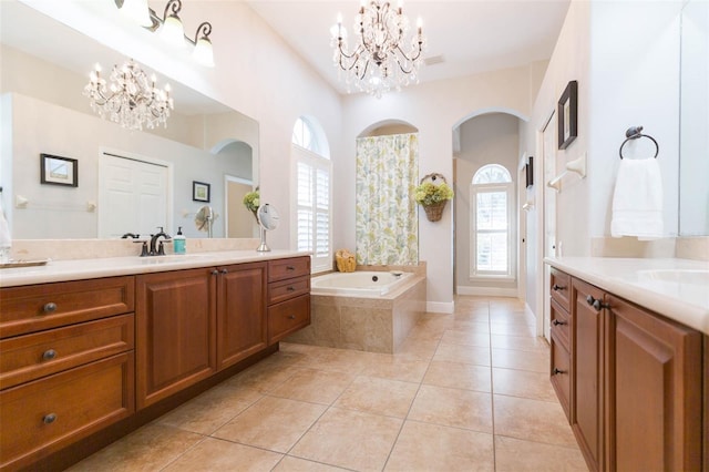 bathroom with vanity, tile patterned flooring, and tiled tub