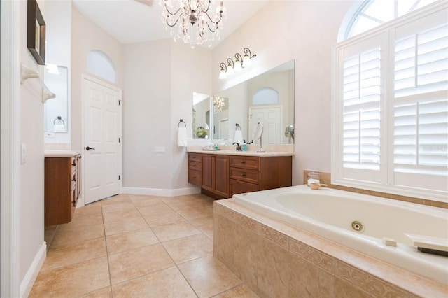 bathroom featuring tile patterned floors, vanity, an inviting chandelier, and a relaxing tiled tub