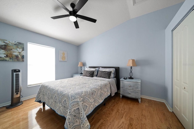 bedroom with lofted ceiling, ceiling fan, a closet, and wood-type flooring