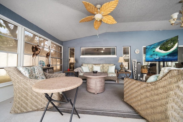 living room featuring ceiling fan, a textured ceiling, and lofted ceiling