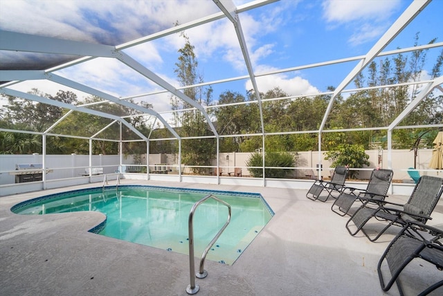 view of swimming pool featuring glass enclosure and a patio