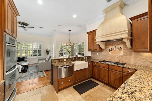 kitchen featuring stone counters, appliances with stainless steel finishes, custom range hood, and a healthy amount of sunlight