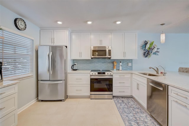 kitchen featuring pendant lighting, white cabinetry, sink, and appliances with stainless steel finishes