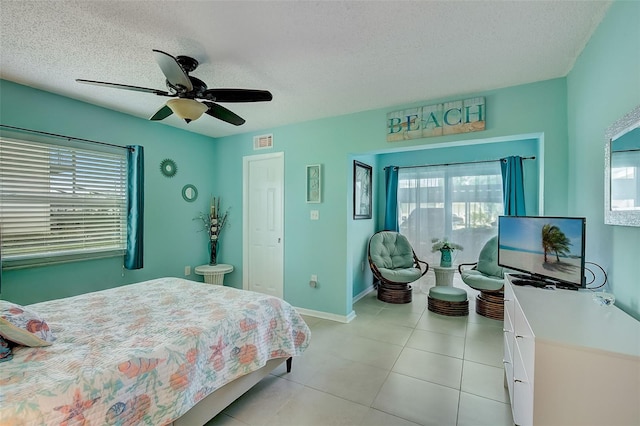 tiled bedroom featuring a textured ceiling and ceiling fan