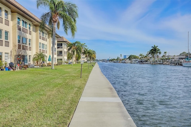 view of community featuring a water view and a lawn