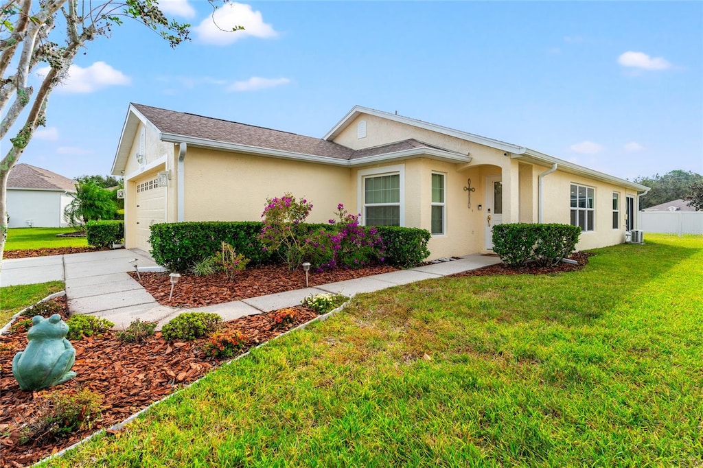 ranch-style house with a garage and a front lawn