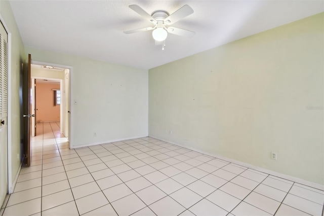 tiled empty room featuring ceiling fan