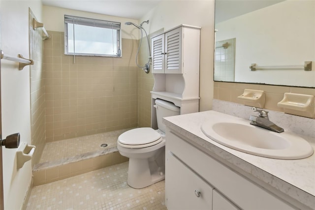 bathroom featuring a tile shower, tasteful backsplash, toilet, vanity, and tile patterned flooring