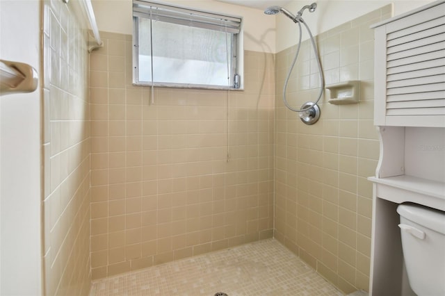 bathroom with a tile shower and toilet