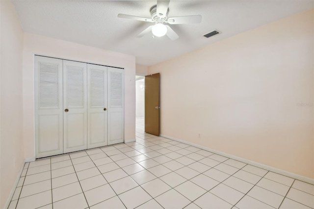 unfurnished bedroom with a closet, light tile patterned flooring, and ceiling fan