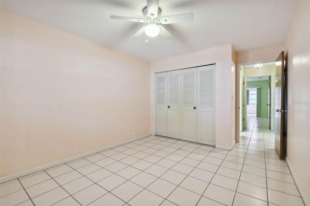 unfurnished bedroom with a closet, a textured ceiling, light tile patterned flooring, and ceiling fan