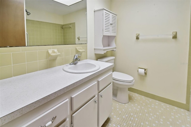 bathroom featuring tasteful backsplash, toilet, tiled shower, vanity, and tile patterned flooring