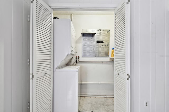 washroom featuring stacked washer and clothes dryer