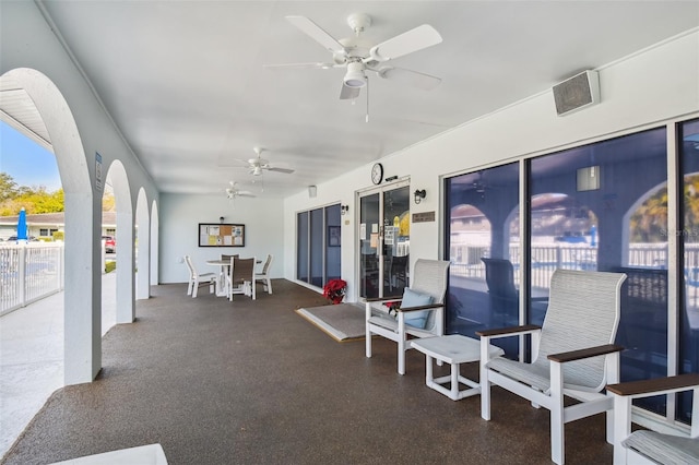 sunroom / solarium featuring ceiling fan