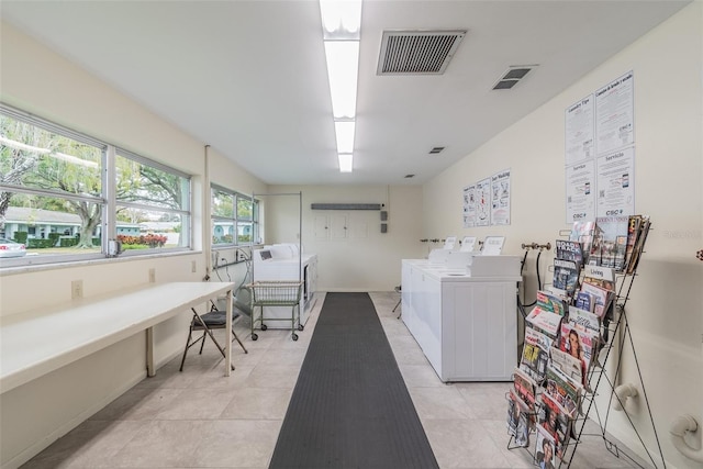 clothes washing area with separate washer and dryer and light tile patterned floors