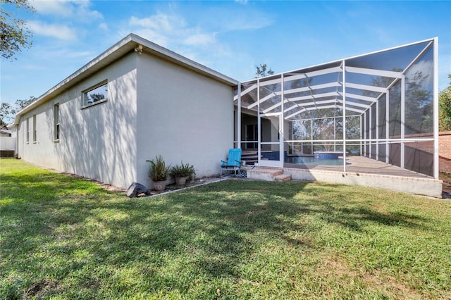 back of house featuring a patio, a lanai, and a lawn