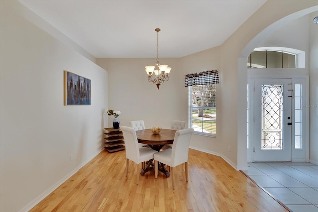 dining space featuring a notable chandelier and light wood-type flooring