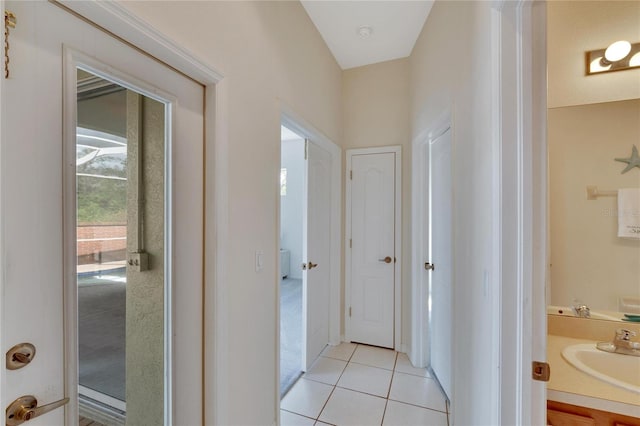 corridor with sink and light tile patterned floors