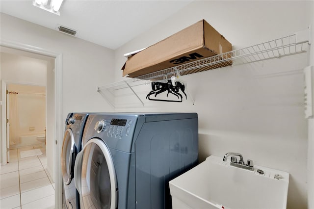 laundry area featuring sink, separate washer and dryer, and light tile patterned floors