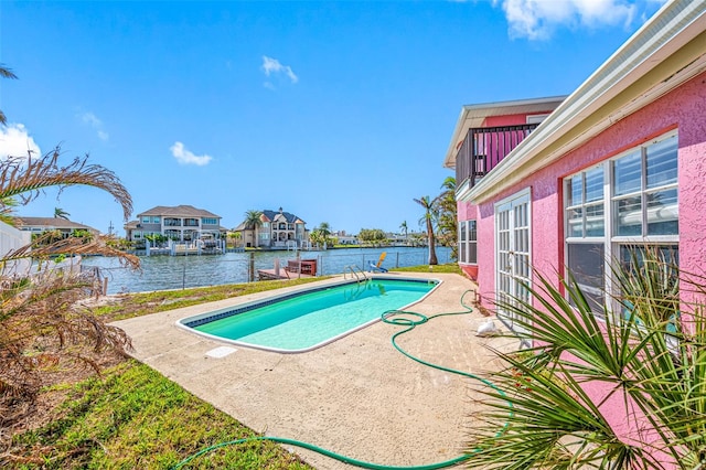 view of swimming pool featuring a water view and a patio