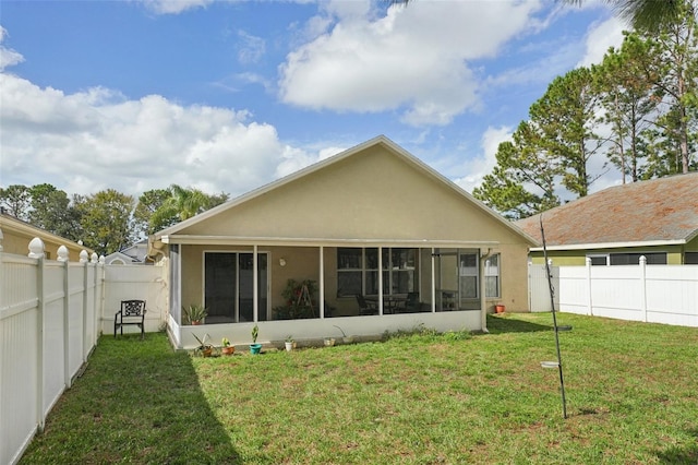 back of house with a lawn and a sunroom