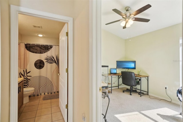 tiled office space featuring ceiling fan