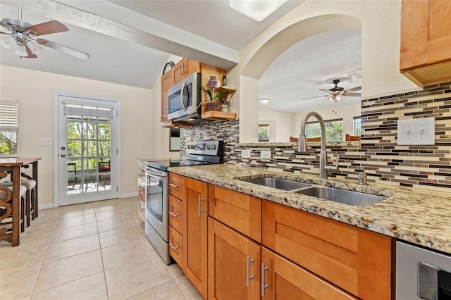 kitchen with appliances with stainless steel finishes, plenty of natural light, and backsplash