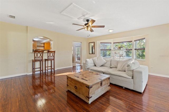 living room featuring ceiling fan and dark hardwood / wood-style flooring