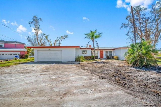 5412 Pali Way, St Pete Beach, FL 33706 - view of front of home featuring driveway, an attached garage, and stucco siding