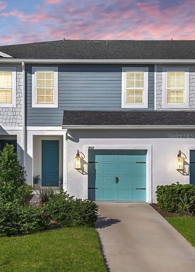 view of property featuring a yard and a garage