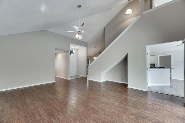 unfurnished living room featuring a textured ceiling, high vaulted ceiling, dark wood-type flooring, and ceiling fan