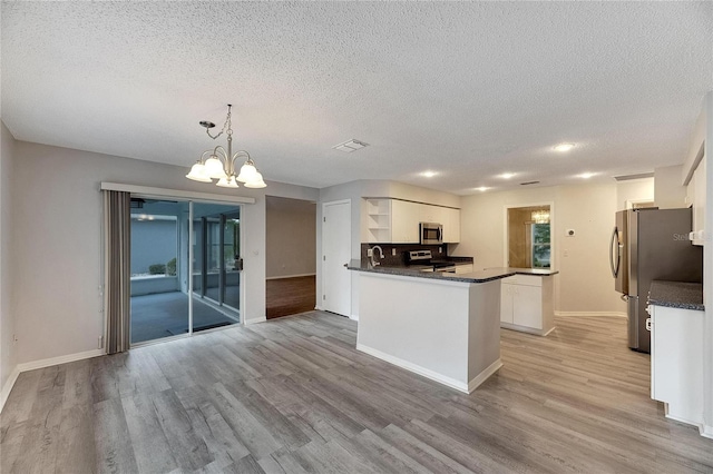 kitchen featuring light hardwood / wood-style floors, white cabinets, and pendant lighting