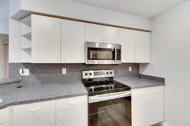 kitchen with decorative backsplash, white cabinetry, and stainless steel appliances