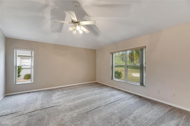 carpeted empty room featuring a textured ceiling and ceiling fan