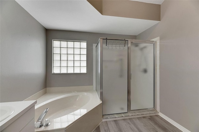 bathroom featuring vanity, hardwood / wood-style floors, and plus walk in shower