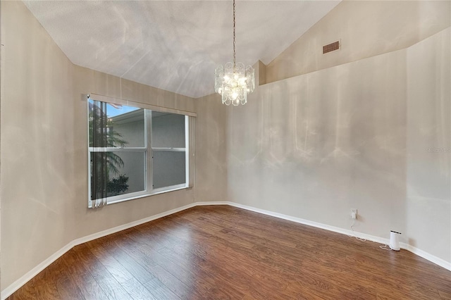 spare room featuring hardwood / wood-style flooring, a textured ceiling, vaulted ceiling, and a chandelier